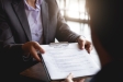 person holding resume on clipboard